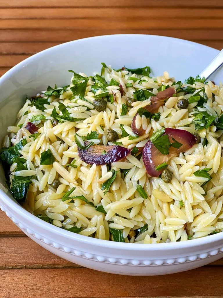 Orzo Pasta Salad in a white bowl, close up.