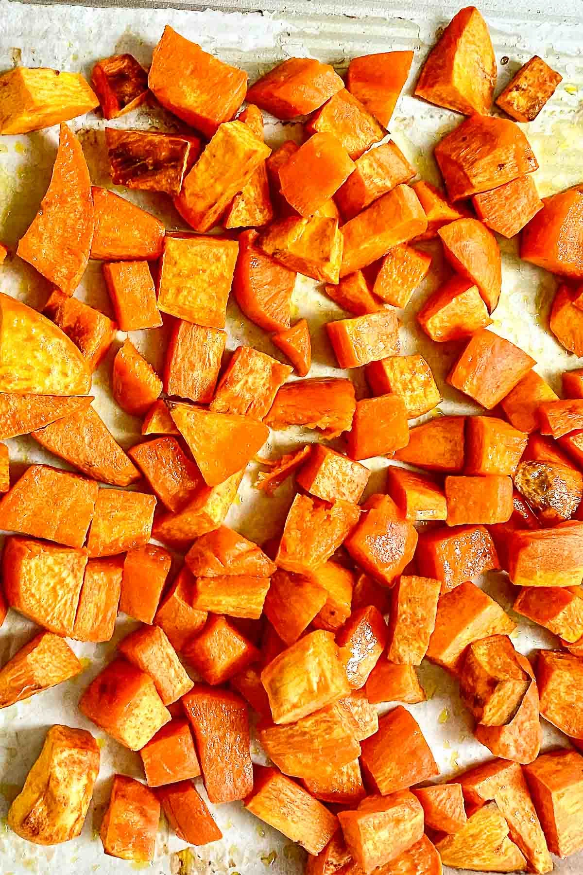Roasted Sweet Potatoes cubed on a baking tray.