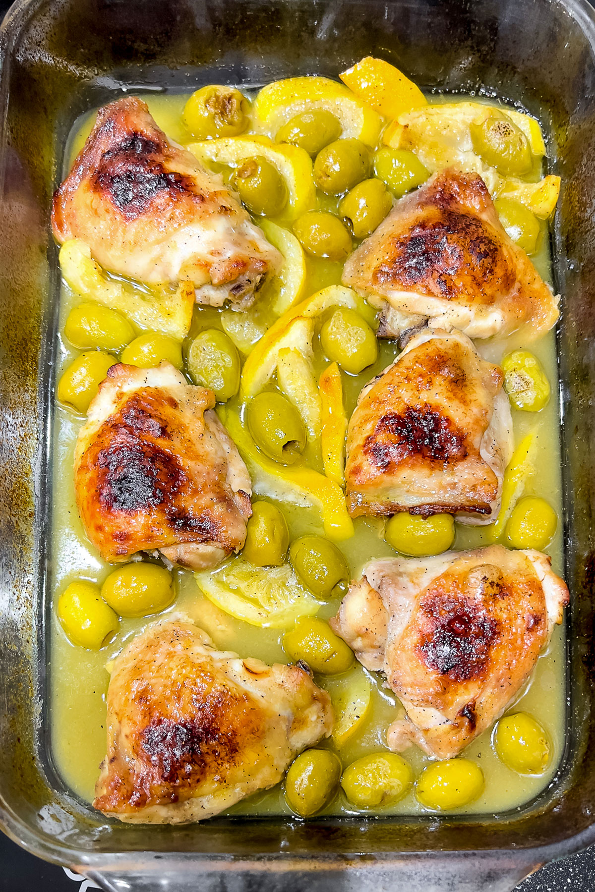 Chicken with olives and lemon in a baking tray0