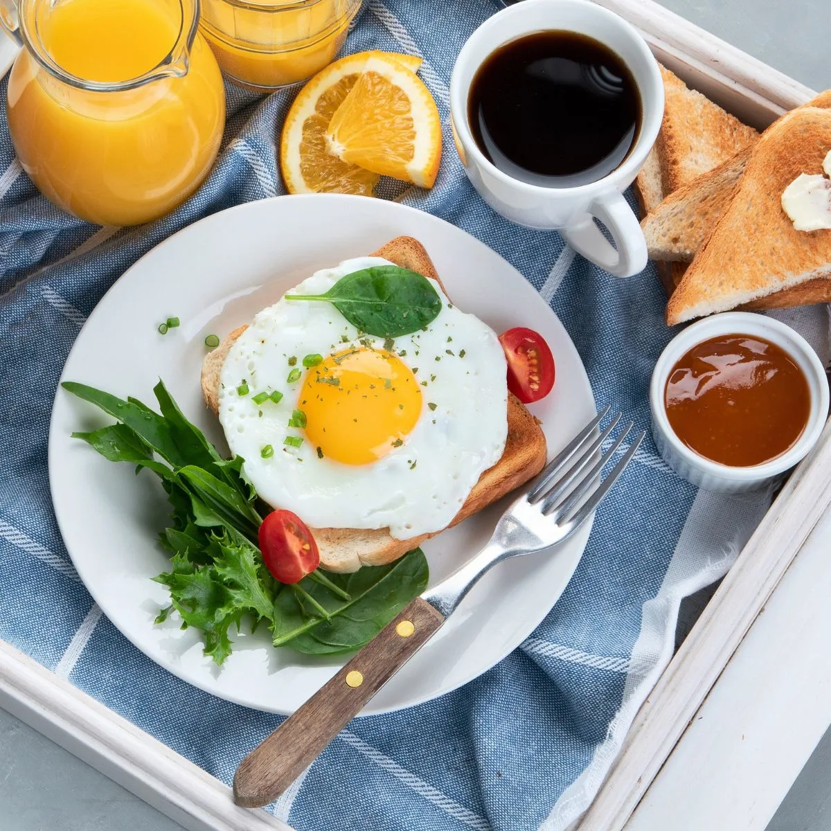 Breakfast Category image Sunny side Up egg on plate with veggies, surrounded by glasses of orange juice, coffee and toast. Breakfast image.