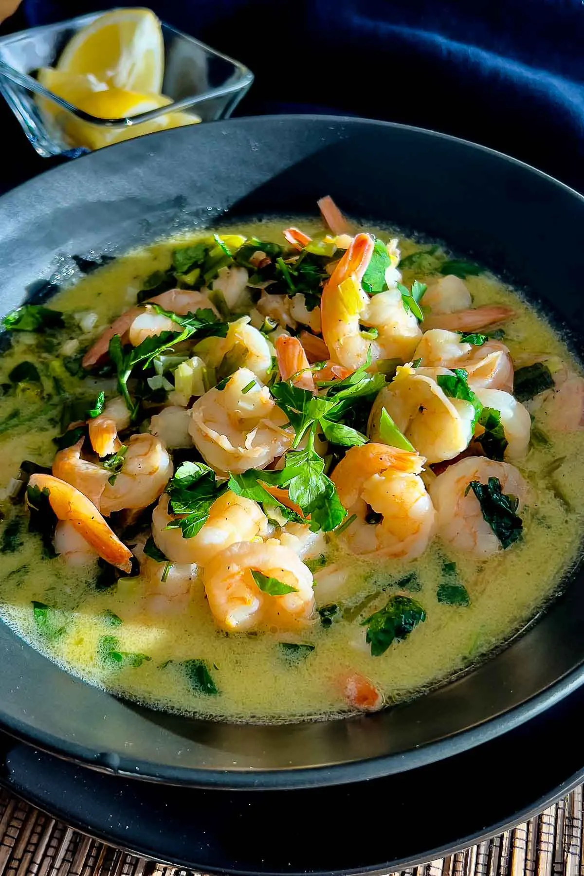 Garlic and Lemon Shrimp served in a black plate with lemon wedges.