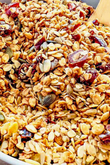 Nuts Free Granola in a white bowl with wooden spoon.