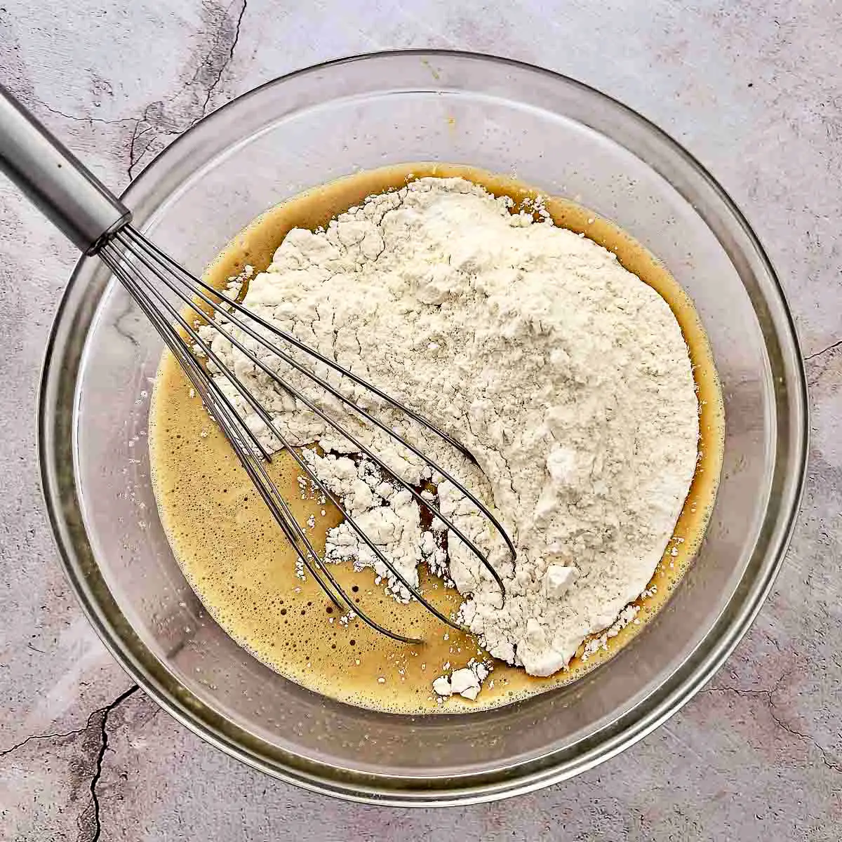 Eggs sugar and flour in a glass bowl.