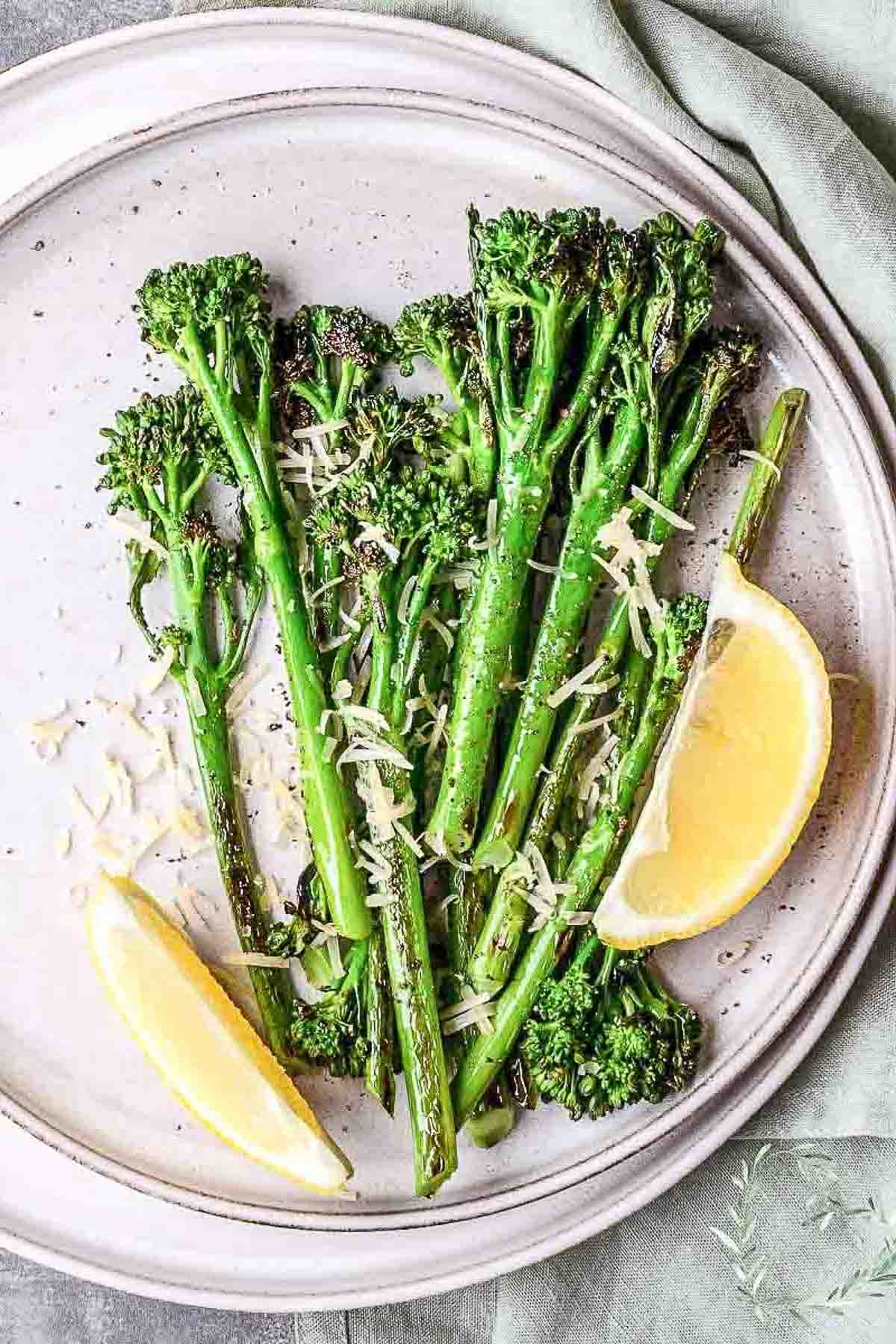Roasted Broccolini With Lemon And Garlic served with parmesan on a white plate.