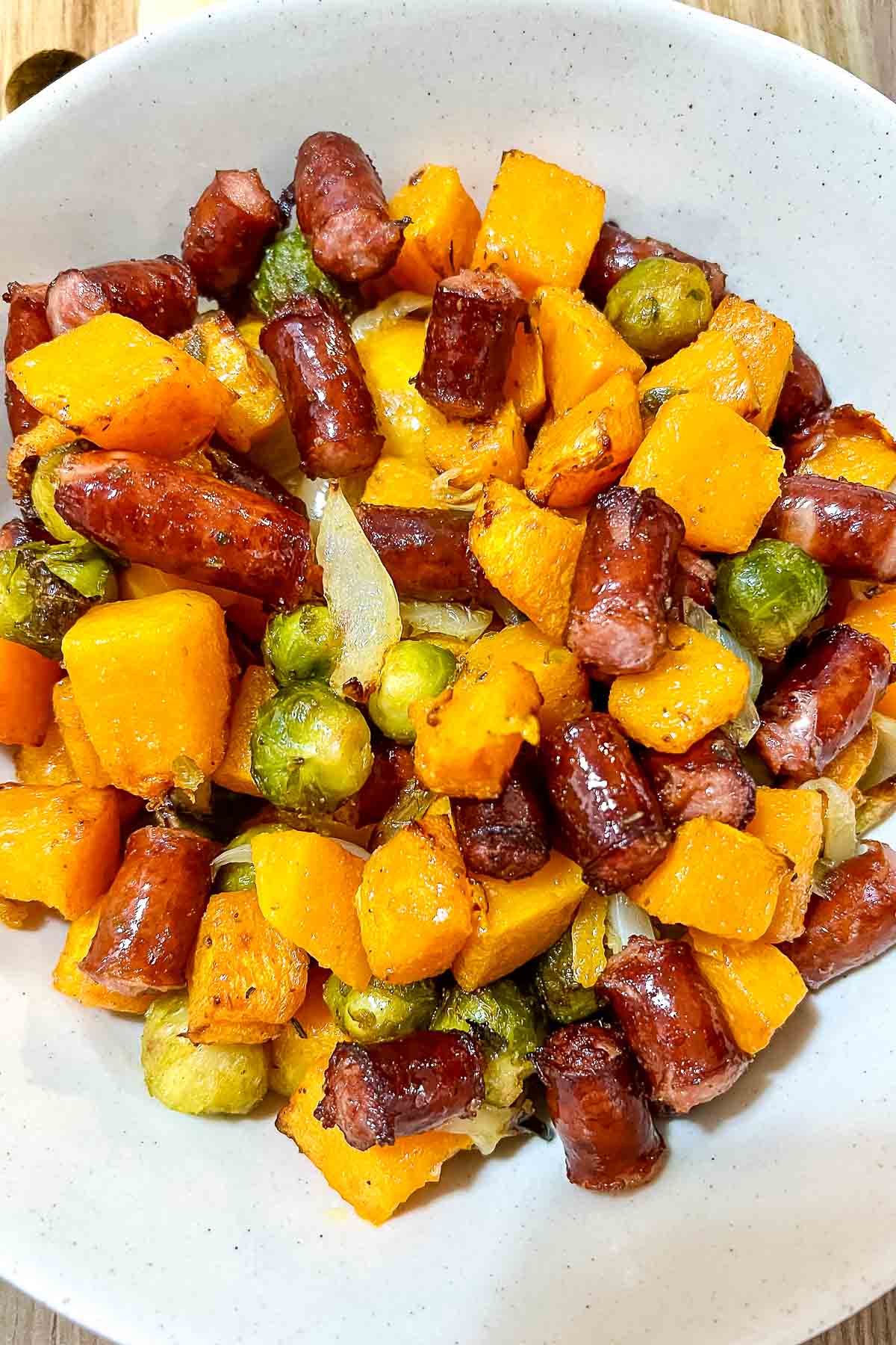 Air Fryer Sausages With Vegetables in a white bowl.
