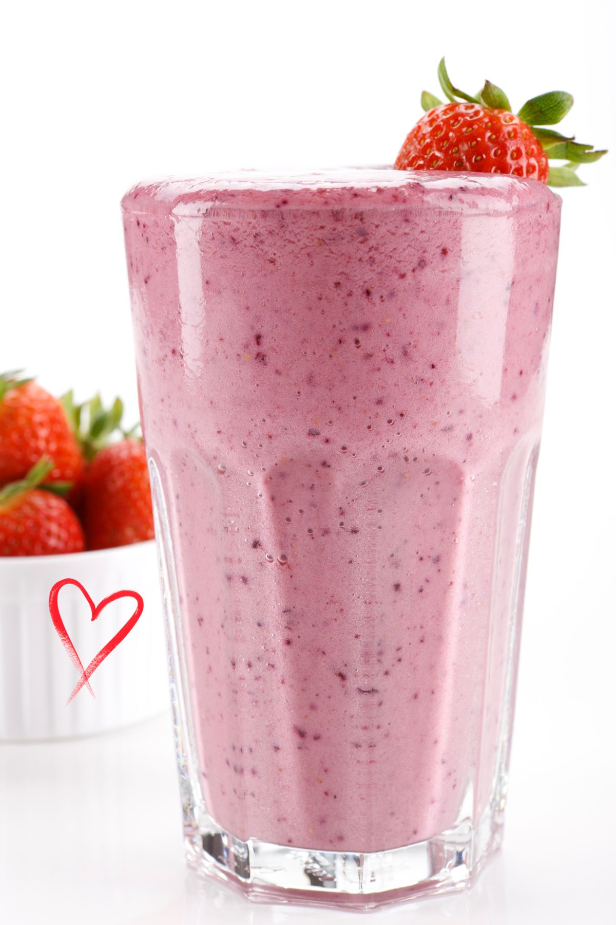 Berry Protein Shake in a tall glass decorated with strawberries.