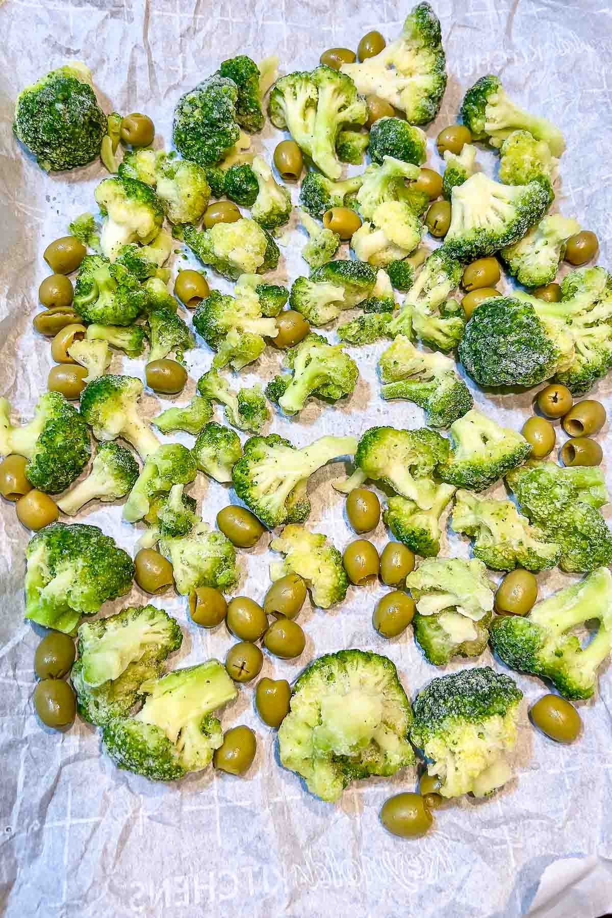 Broccoli and olives in a roasting pan.
