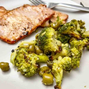 Lomo adobado served with roasted broccoli and olives.