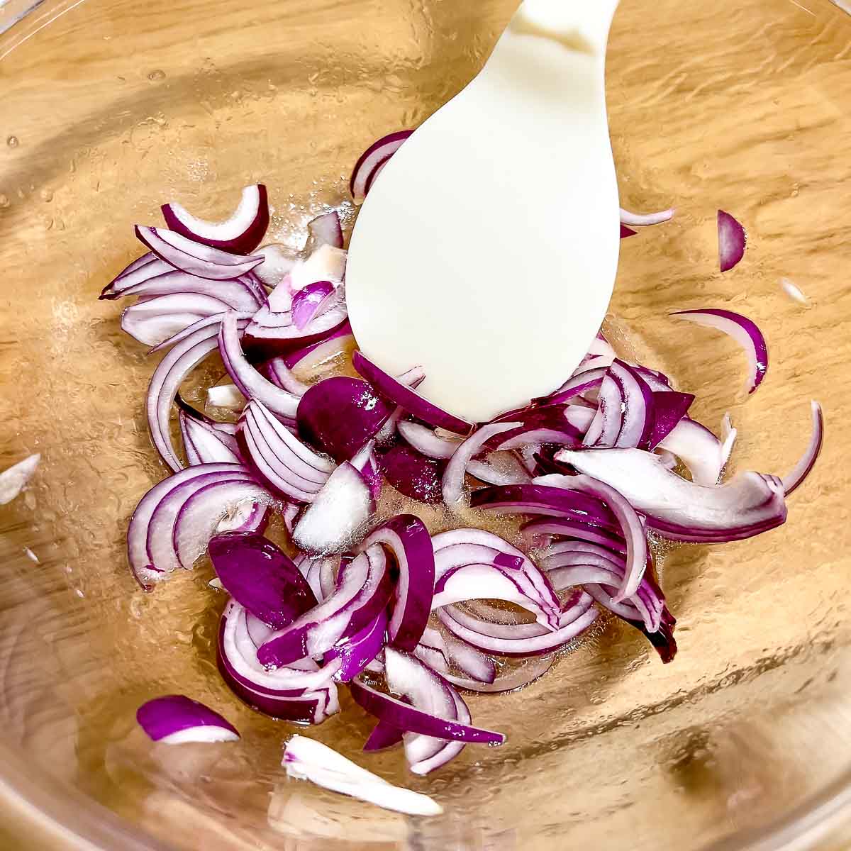 Red onion marinating in salad dressing.