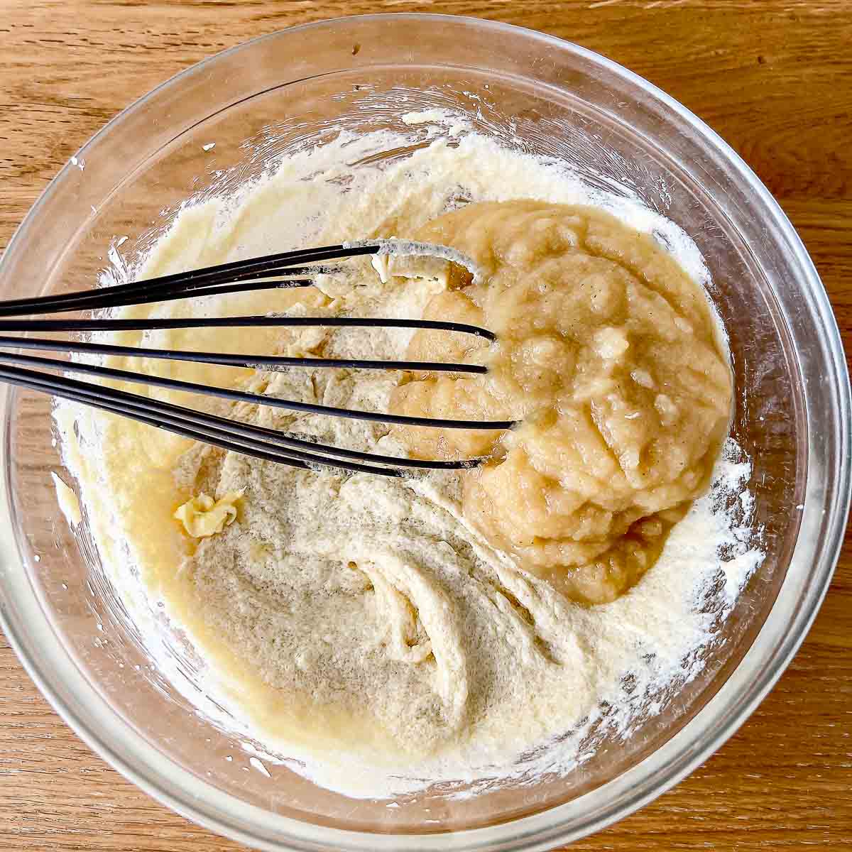 Adding applesauce to the mixture.