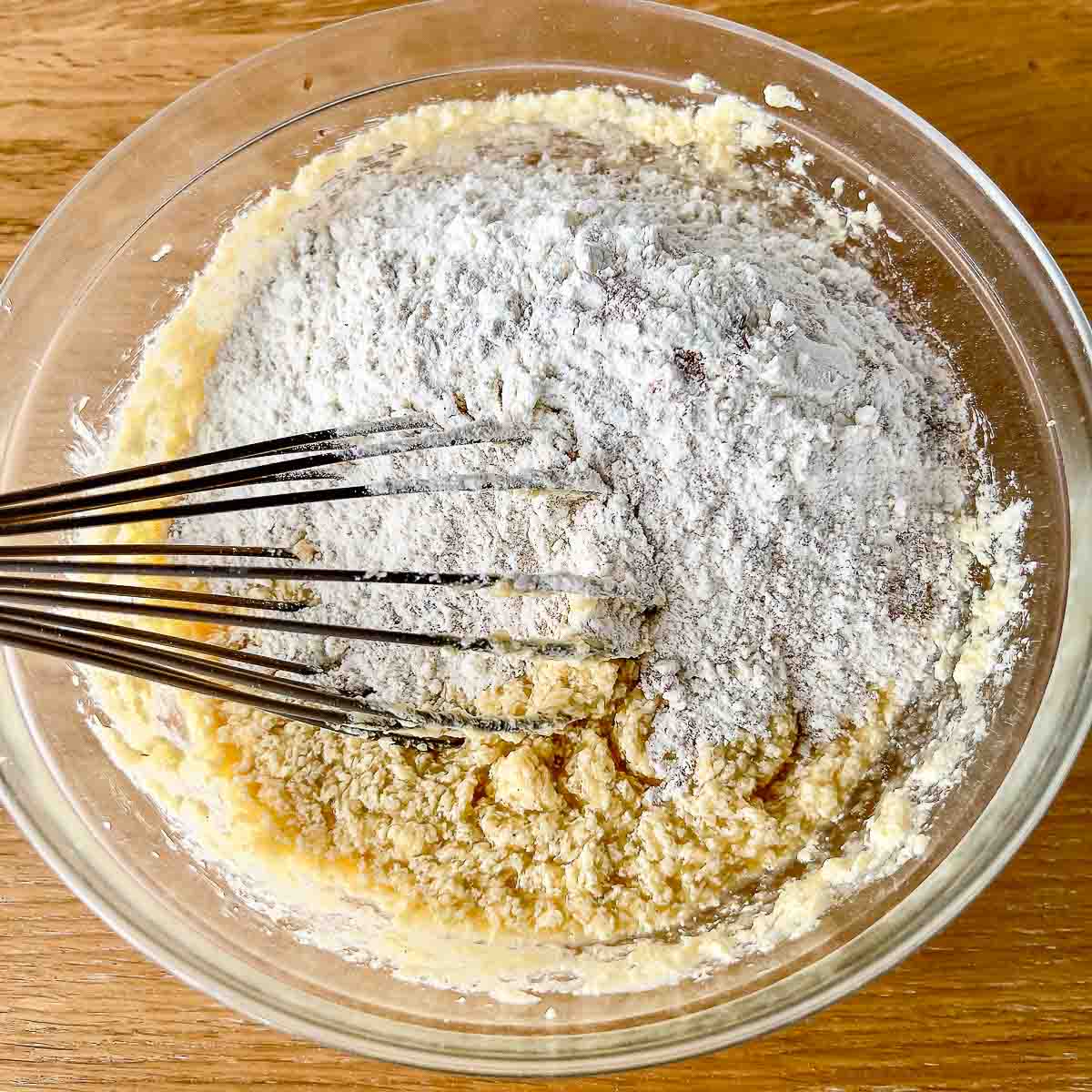 Adding dry ingredients to the wet ones.