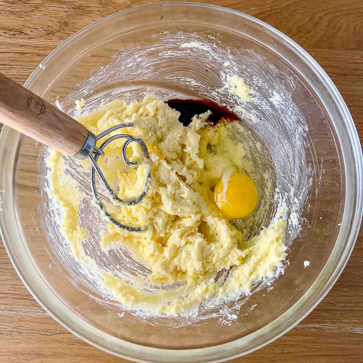 Adding egg and vanilla to butter and sugar.