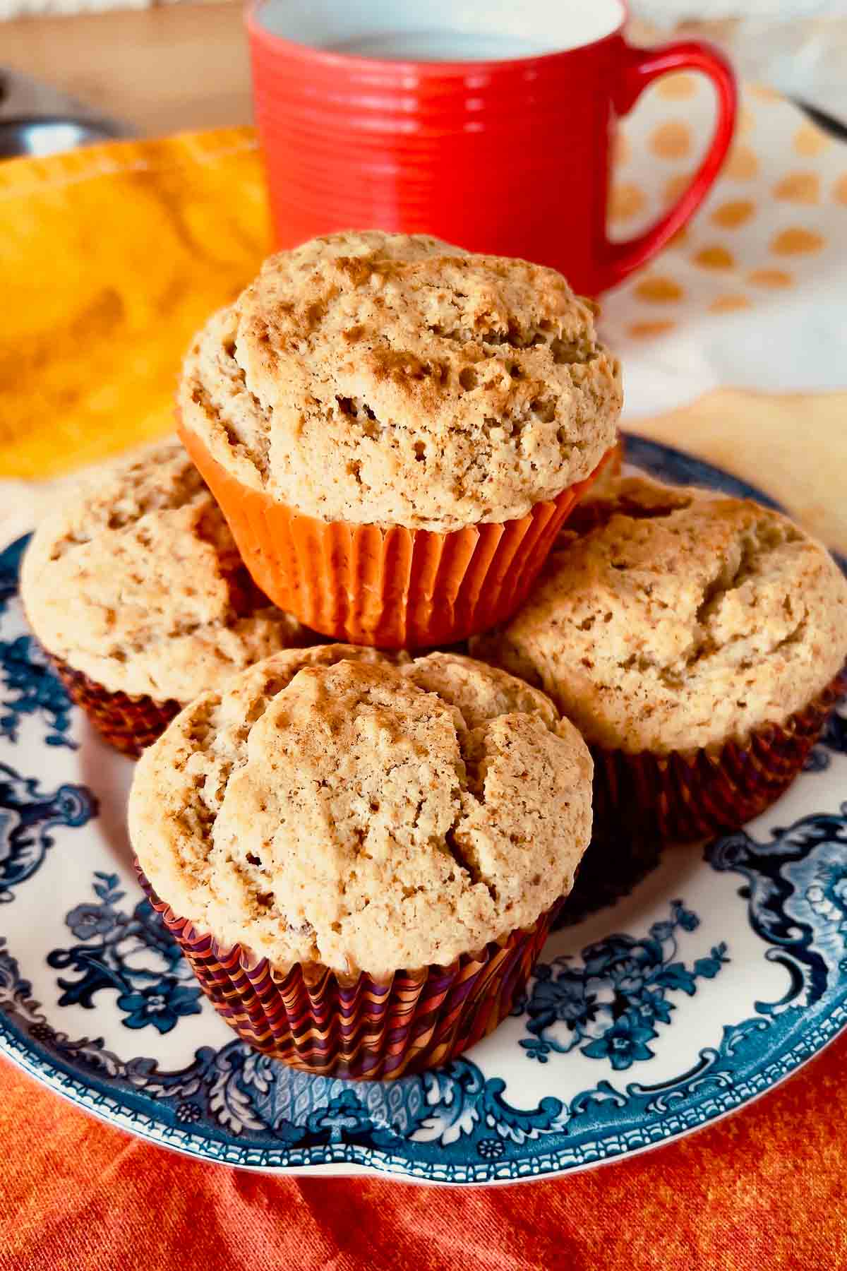 Applesauce muffins stacked on a plate.