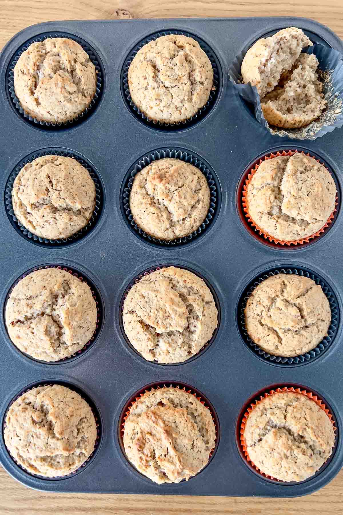 Baked applesauce spice muffins in a pan.