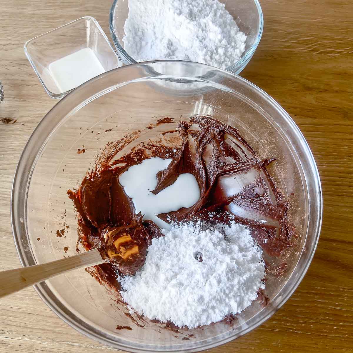 Mixing butter with cocoa powder, milk and powdered sugar.